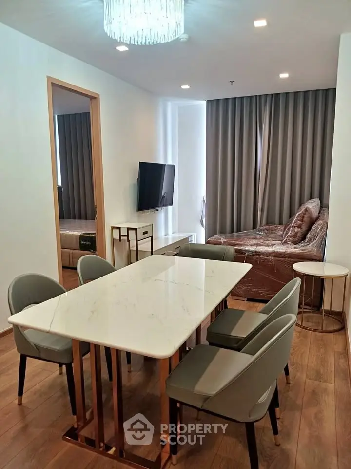Modern dining area with elegant marble table and stylish chairs in a cozy apartment setting.