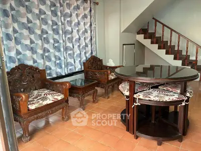Charming living room with elegant wooden furniture and staircase, perfect for cozy gatherings.