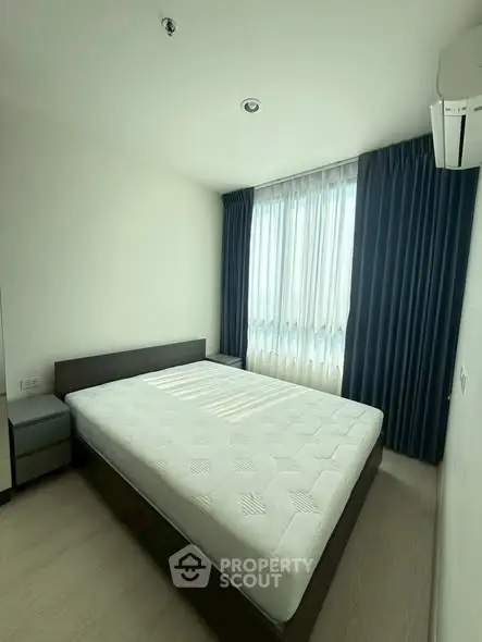 Modern bedroom with large window and minimalist design in a high-rise apartment.