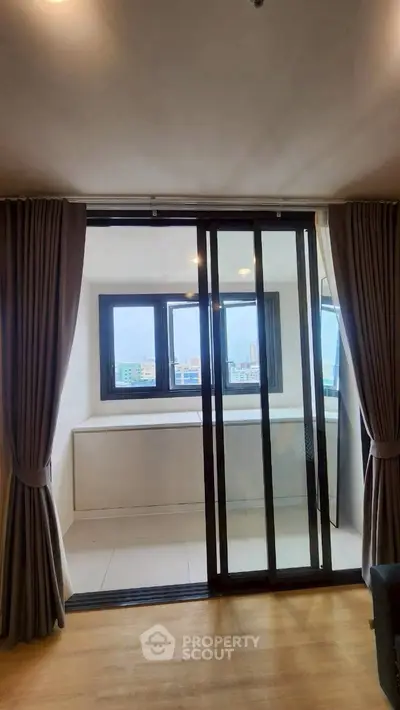 Modern apartment with sliding glass doors leading to a bright balcony with city views.