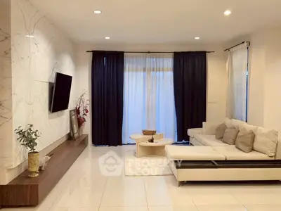 Elegant living room with modern decor, featuring a sleek TV setup and cozy seating area.