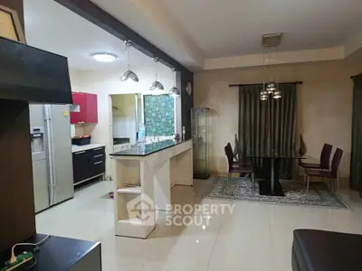 Spacious open-plan kitchen and dining area with modern appliances and elegant lighting.