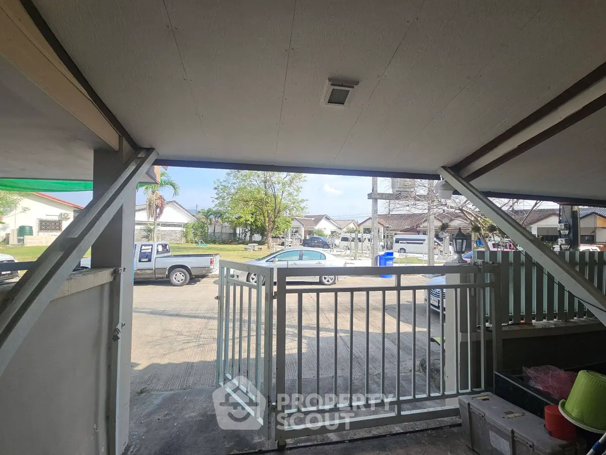 Charming residential neighborhood with gated driveway and parked vehicles, showcasing suburban living.