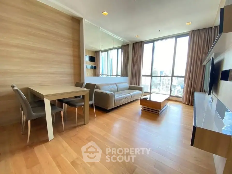 Spacious modern living room with city view, wooden flooring, and elegant furniture.