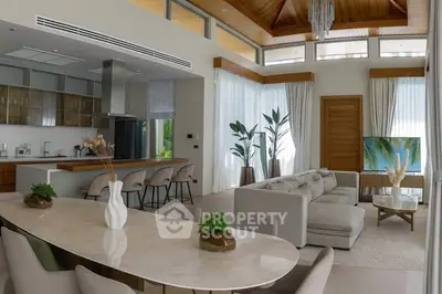 Luxurious open-plan living room with modern kitchen and elegant dining area, featuring high ceilings and natural light.