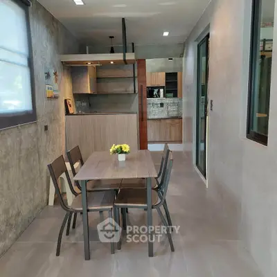 Modern dining area with sleek kitchen in open layout, featuring stylish decor and ample natural light.