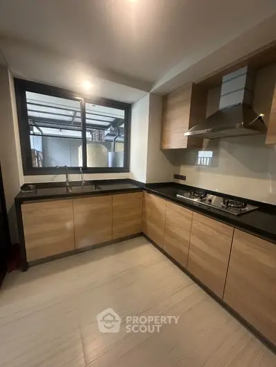 Modern kitchen with sleek wooden cabinets and gas stove