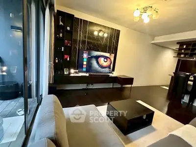 Modern living room with sleek design and large TV, featuring dark wood flooring and stylish lighting.
