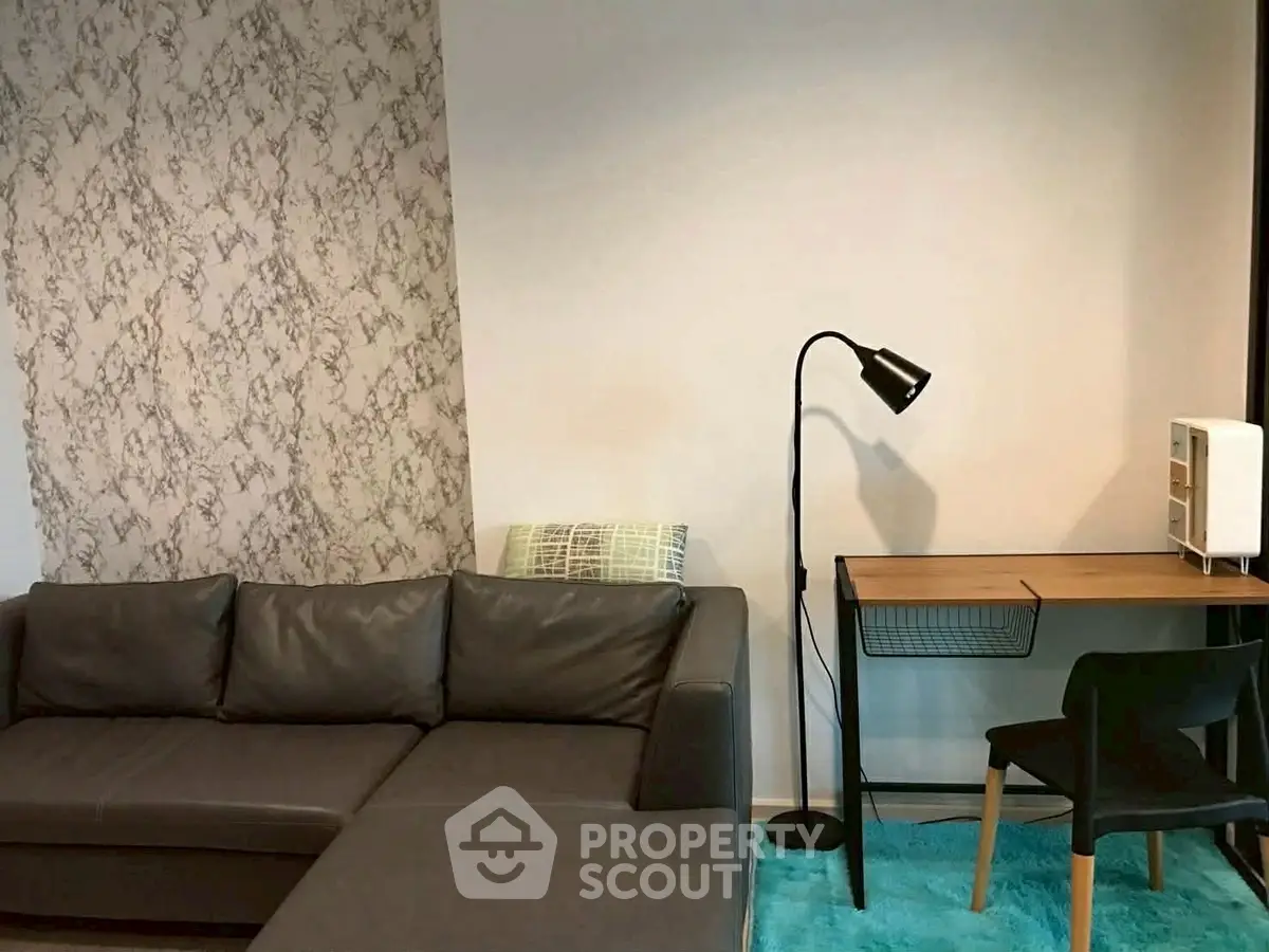 Modern living room with stylish sofa and workspace, perfect for urban living.