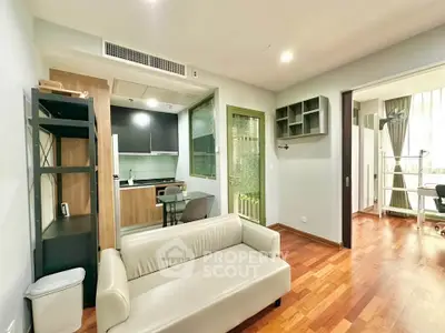 Modern living room with open kitchen and wooden flooring in a stylish apartment