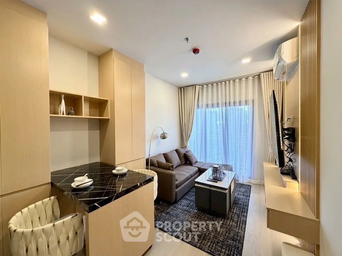 Modern living room with elegant decor and open layout, featuring cozy seating and stylish lighting.