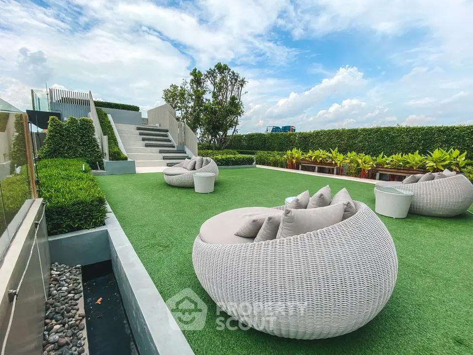 Luxurious rooftop garden with modern seating and lush greenery under a vibrant sky.