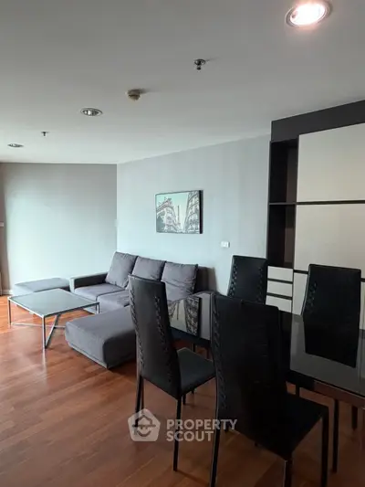 Modern living room with sleek furniture and wooden flooring in a stylish apartment.
