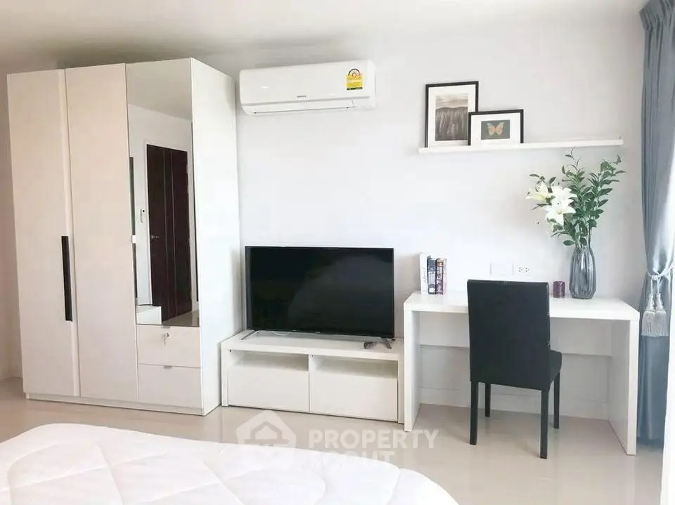 Modern bedroom with sleek furniture, TV, and air conditioning, perfect for comfort and style.