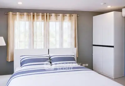 Modern bedroom with stylish decor and ample natural light