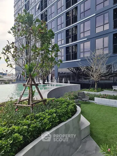Modern building with lush garden and poolside area, perfect for luxury living.