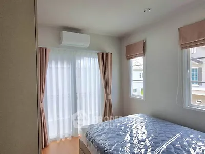 Bright bedroom with large windows and modern air conditioning unit