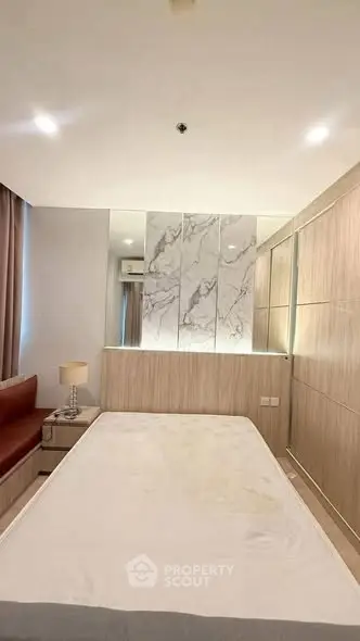 Modern bedroom with elegant marble accent wall and cozy lighting