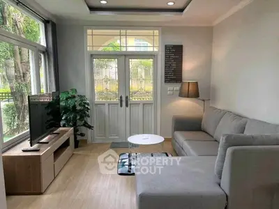 Charming living room with modern decor, large window, and cozy seating area.
