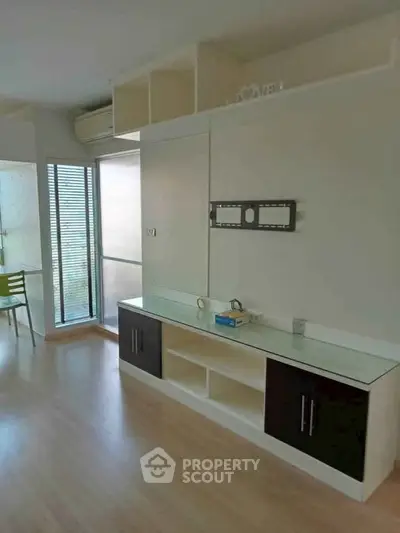 Modern living room with built-in TV mount and large windows for natural light.