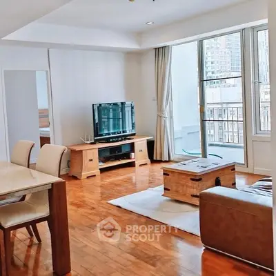 Spacious living room with wooden flooring and city view balcony