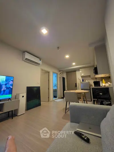 Modern living room with open kitchen layout and cozy seating area, perfect for urban living.