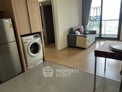 Modern apartment with washing machine and balcony view, featuring open layout and cozy living area.