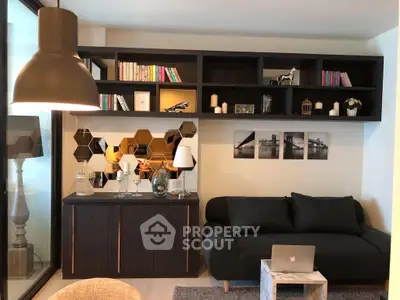 Stylish modern living room with sleek black sofa, decorative shelving, and ambient lighting.