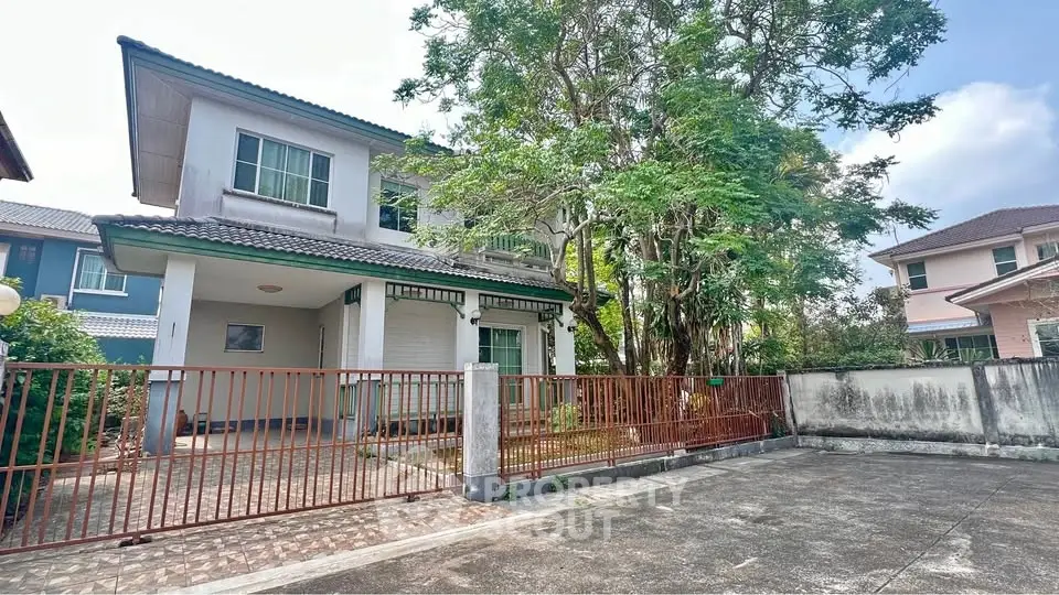 Charming two-story house with spacious driveway and lush greenery