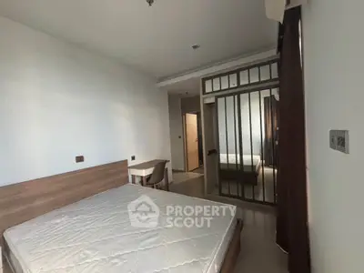 Spacious bedroom with modern design and ample natural light, featuring a comfortable bed and stylish furnishings.