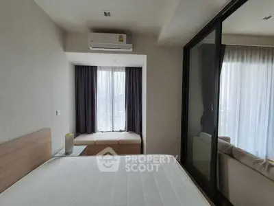 Modern bedroom with large window and air conditioning in a stylish apartment.