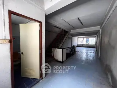 Spacious industrial-style interior with staircase and large windows, ideal for creative workspace or loft conversion.