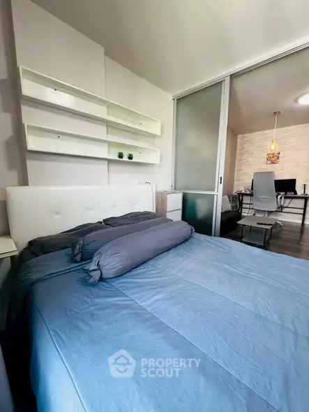 Modern bedroom with sliding glass door and cozy blue bedding