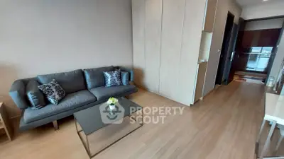 Modern living room with sleek sofa and glass coffee table in stylish apartment.