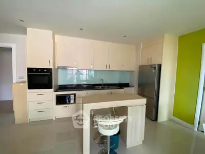 Modern kitchen with sleek cabinetry, built-in oven, and stylish breakfast bar in a contemporary apartment.