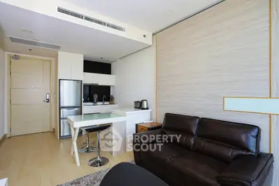 Modern open-layout living room with sleek kitchen and stylish furniture in a contemporary apartment.