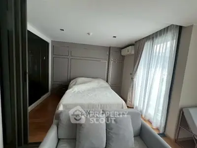 Modern bedroom with cozy sofa and large windows for natural light