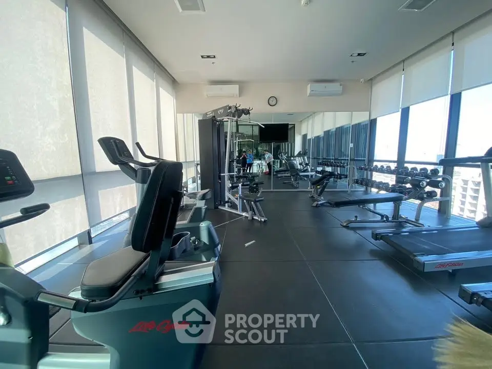 Modern gym with state-of-the-art equipment and panoramic city views, perfect for fitness enthusiasts.