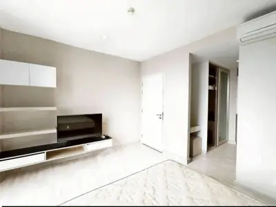 Modern minimalist living room with sleek TV unit and air conditioning.