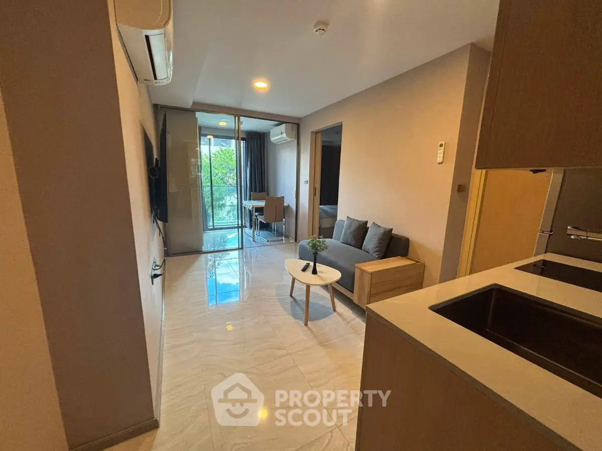 Modern apartment interior with open layout, featuring cozy living room and balcony view.