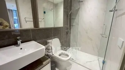 Modern bathroom with sleek design, featuring a spacious shower and elegant fixtures.