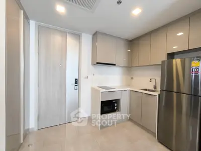 Modern kitchen with sleek cabinetry and stainless steel appliances in a stylish apartment.