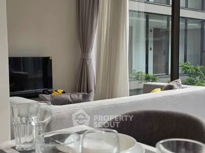 Modern living room with large windows and elegant decor, offering a bright and inviting atmosphere.