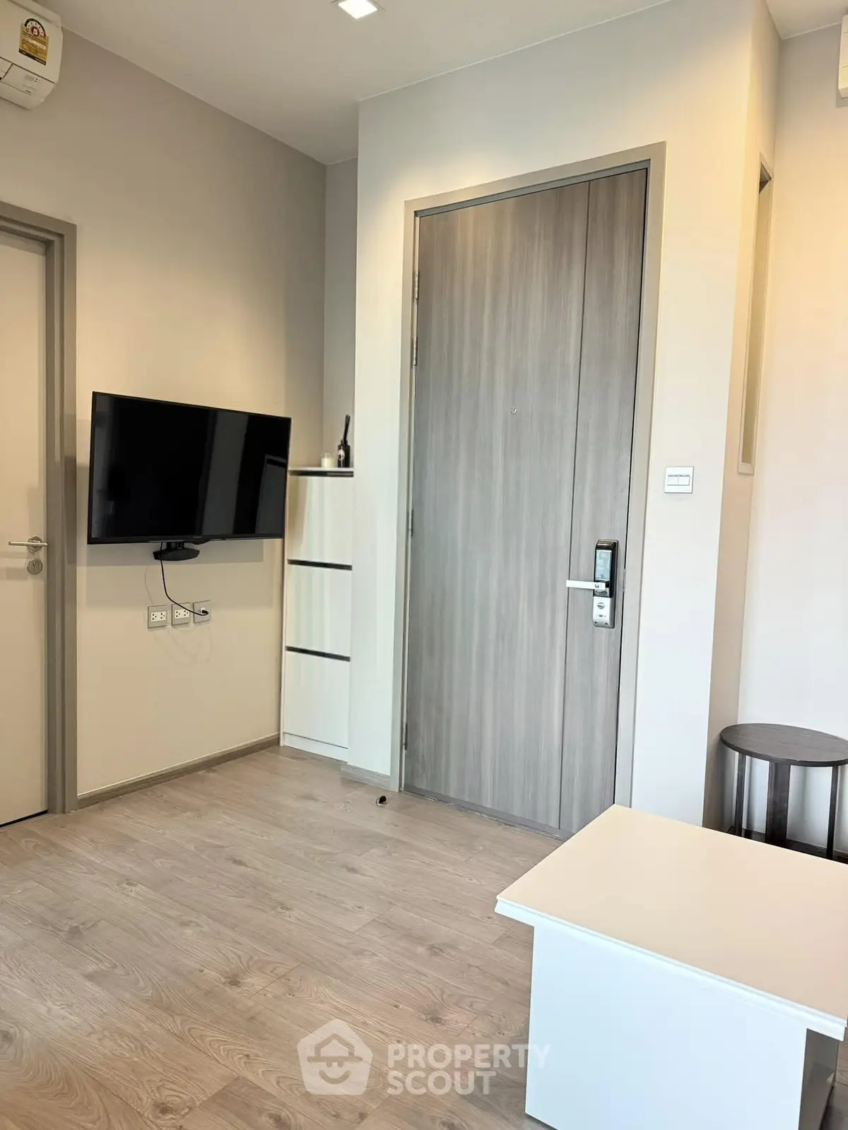 Modern living room with wall-mounted TV and sleek wooden flooring
