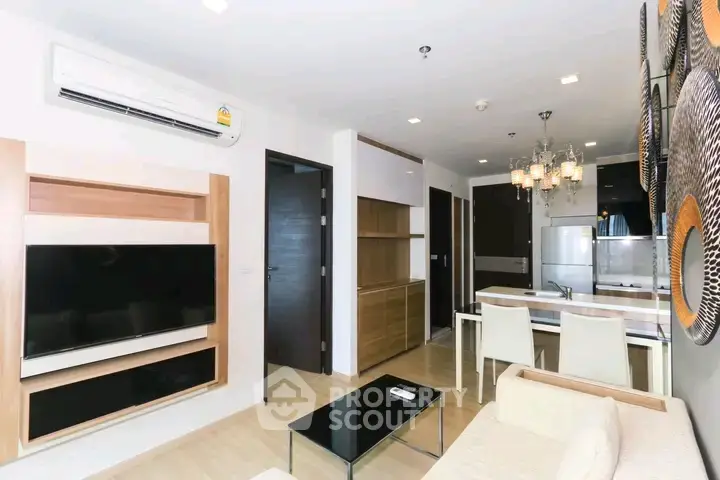 Modern living room with open kitchen, sleek furniture, and stylish decor in a contemporary apartment.