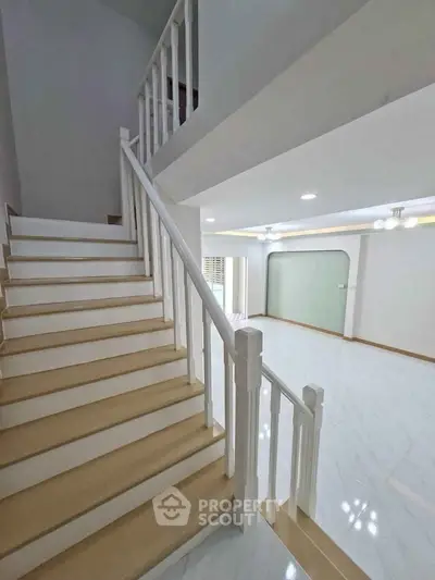 Spacious modern interior with elegant staircase and open living area, perfect for family gatherings.