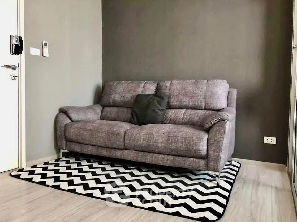 Modern living room with stylish gray sofa and chevron rug