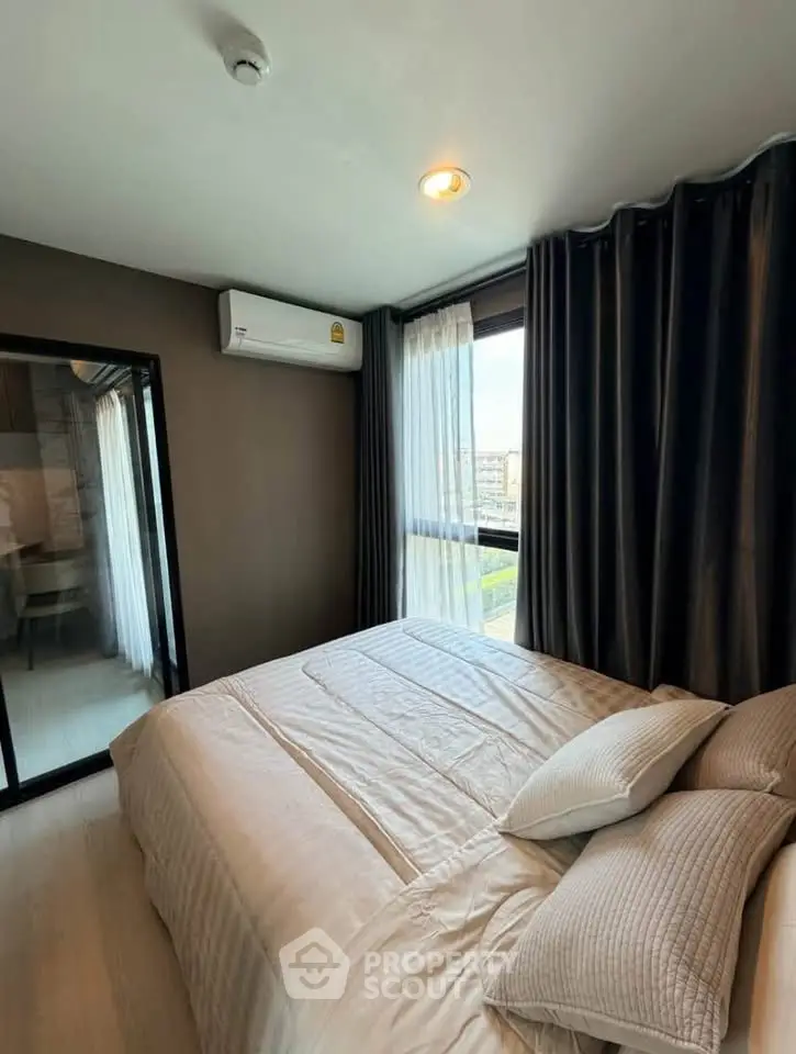 Cozy bedroom with large window and modern decor in a stylish apartment.