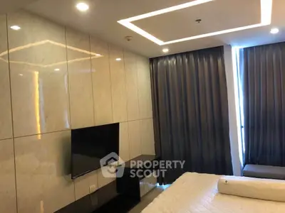 Modern bedroom with sleek design, featuring a wall-mounted TV and elegant lighting.