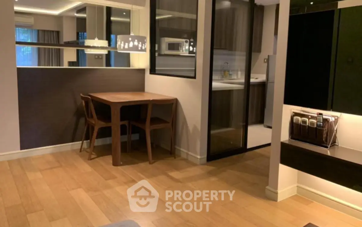 Modern dining area with wooden flooring and sleek kitchen design